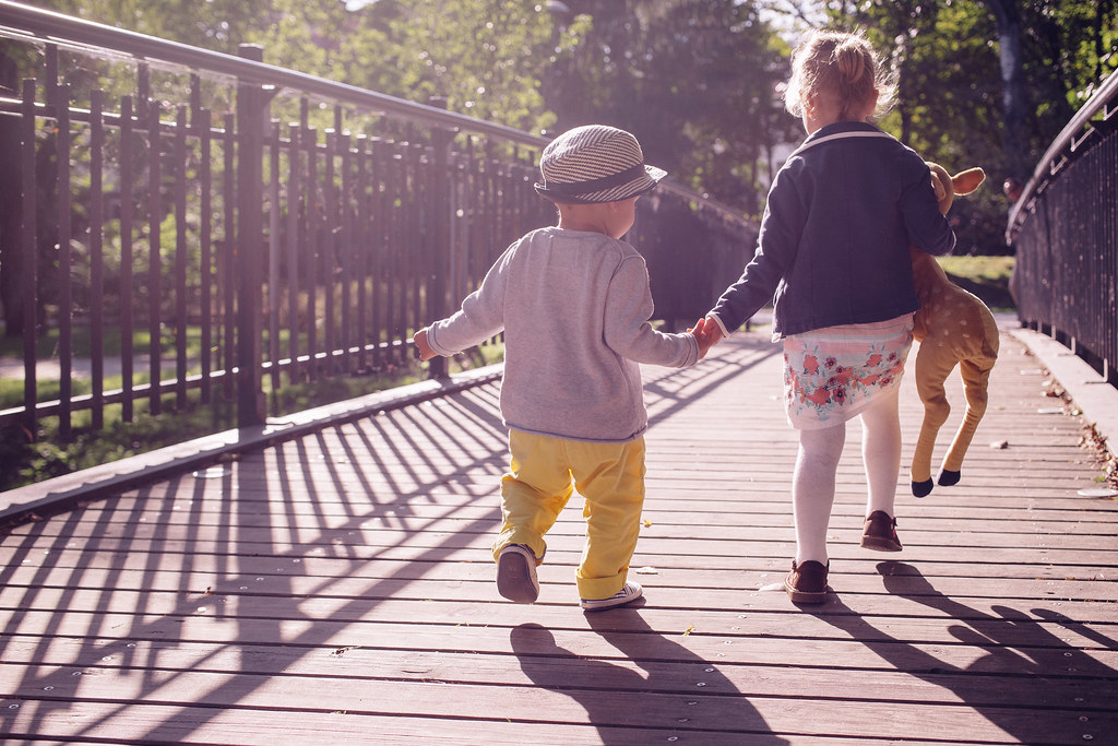 Deux enfants se tenant la main sur un pont en bois